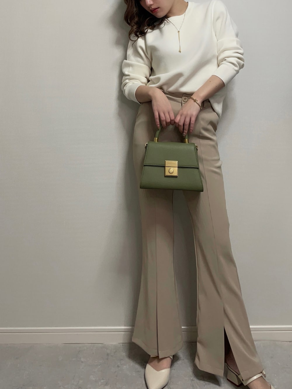 ホワイト系のニット/セーター、ベージュ系のパンツ、ホワイト系のシューズを着用したレディースの冬コーディネートの3枚目の写真