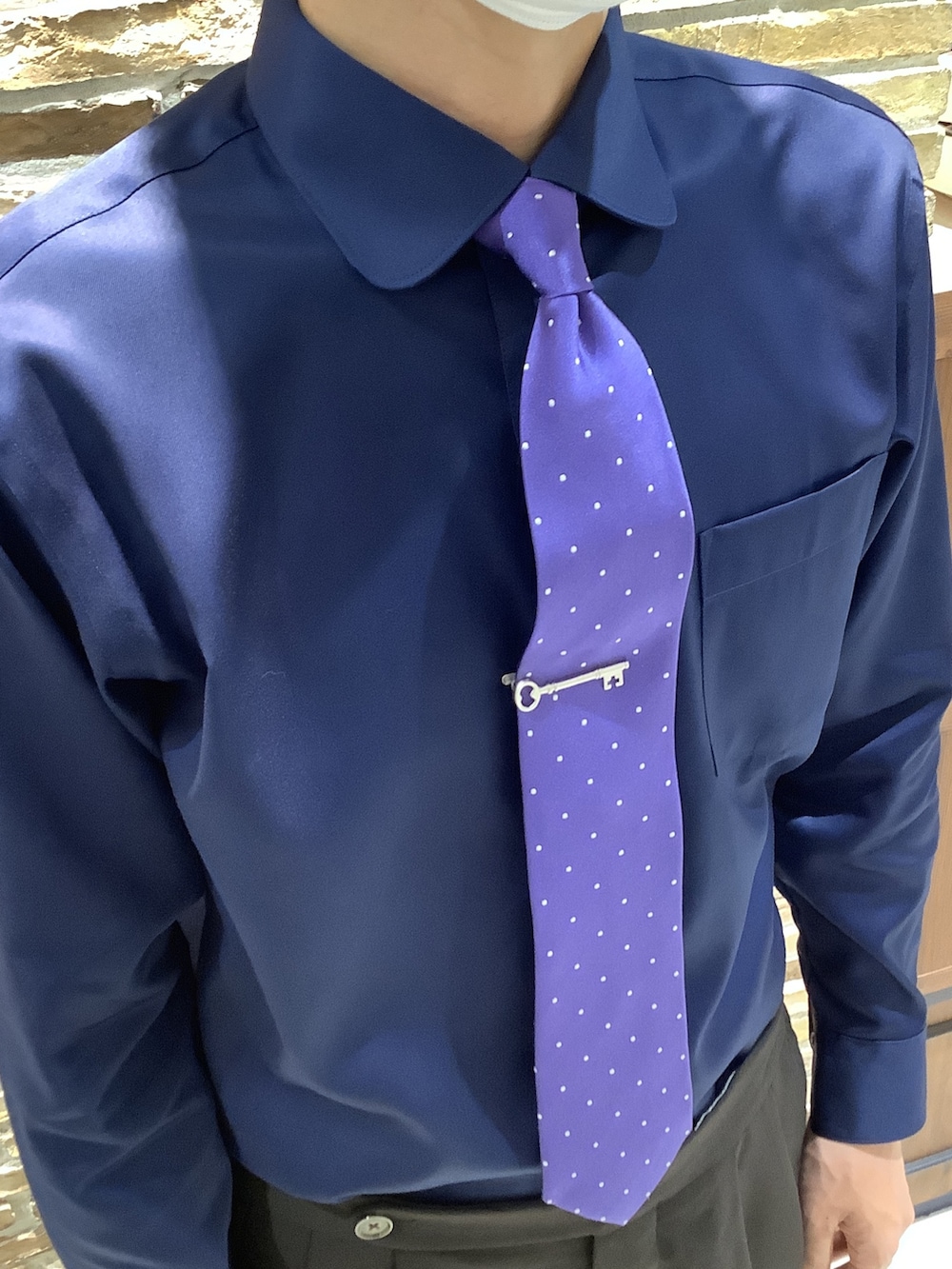 シルバー系のネクタイピン、ブルー系のビジネスシャツを着用したメンズの秋コーディネートの5枚目の写真