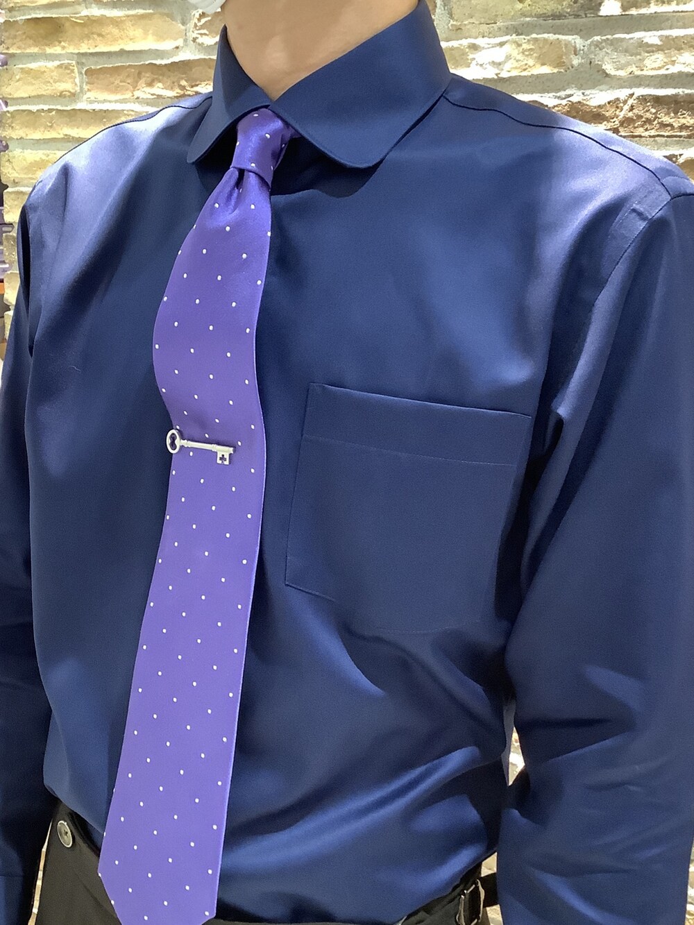 シルバー系のネクタイピン、ブルー系のビジネスシャツを着用したメンズの秋コーディネートの4枚目の写真