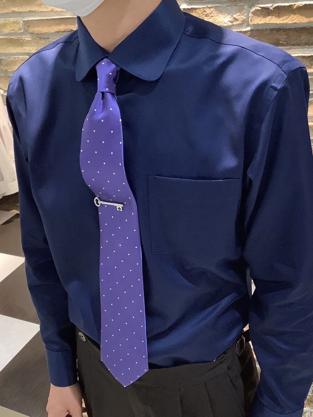 シルバー系のネクタイピン、ブルー系のビジネスシャツを着用したメンズの秋コーディネートの2枚目の写真