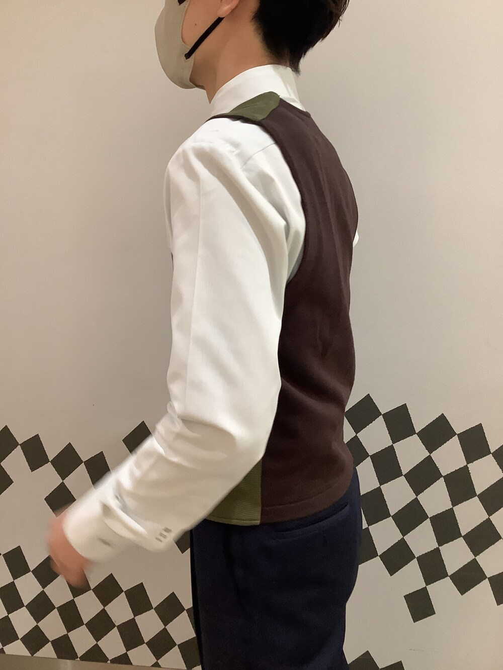 グリーン系のビジネスシャツ、グリーン系のベストを着用したメンズの冬コーディネートの3枚目の写真