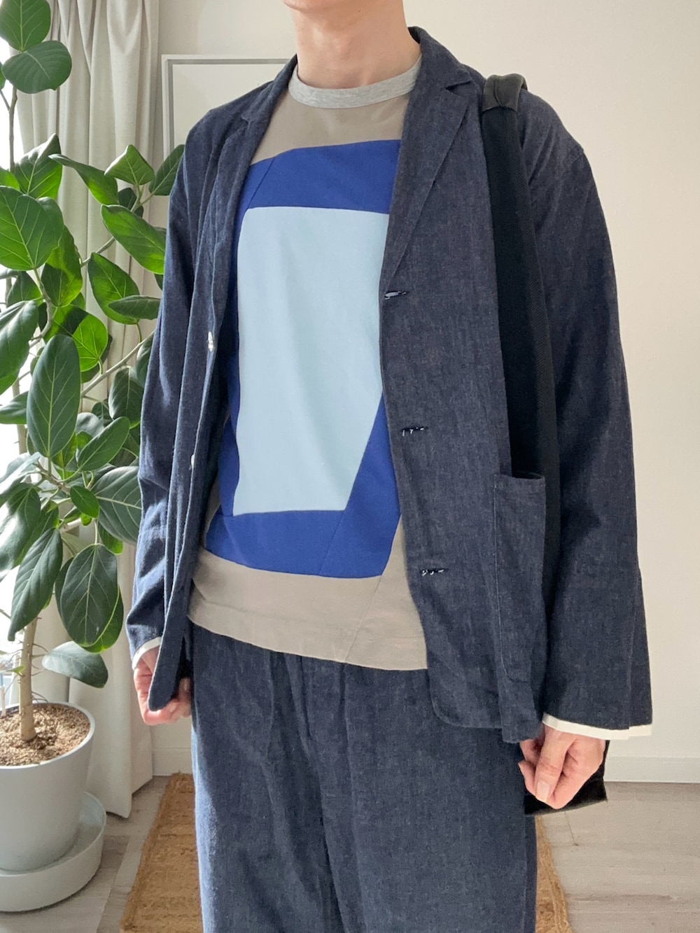ブラック系のトートバッグ、ブラック系のローファー、ブルー系のTシャツ/カットソーを着用したメンズの秋コーディネートの4枚目の写真