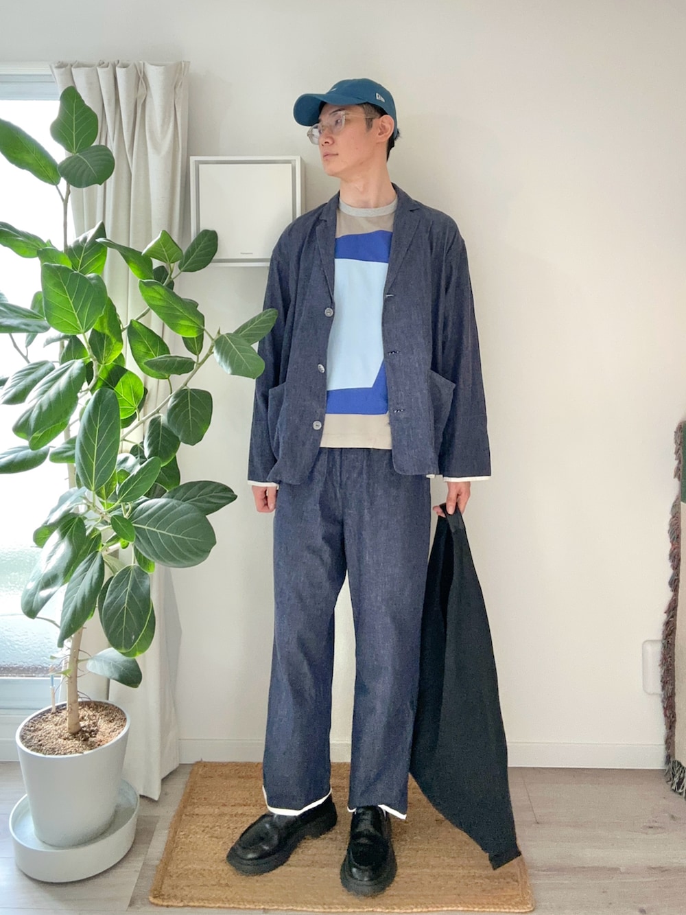 ブラック系のトートバッグ、ブラック系のローファー、ブルー系のTシャツ/カットソーを着用したメンズの秋コーディネートの2枚目の写真