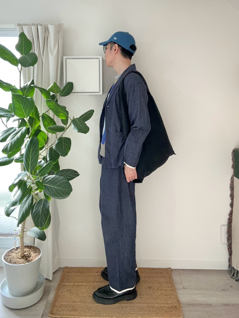 ブラック系のトートバッグ、ブラック系のローファー、ブルー系のTシャツ/カットソーを着用したメンズの秋コーディネートの3枚目の写真