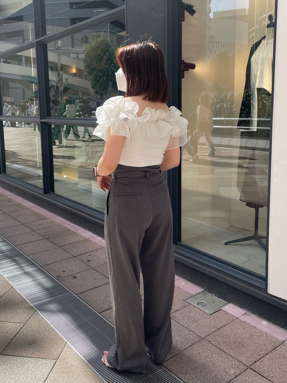 グレー系のスラックス、ホワイト系のシャツ/ブラウスを着用したレディースの春コーディネートの3枚目の写真