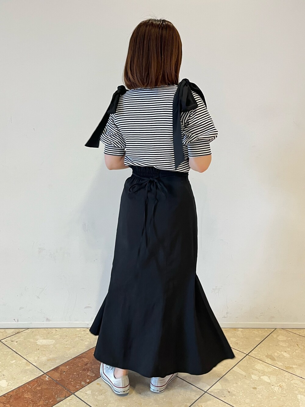 ブラック系のTシャツ/カットソー、ブラック系のスカートを着用したレディースの春コーディネートの2枚目の写真