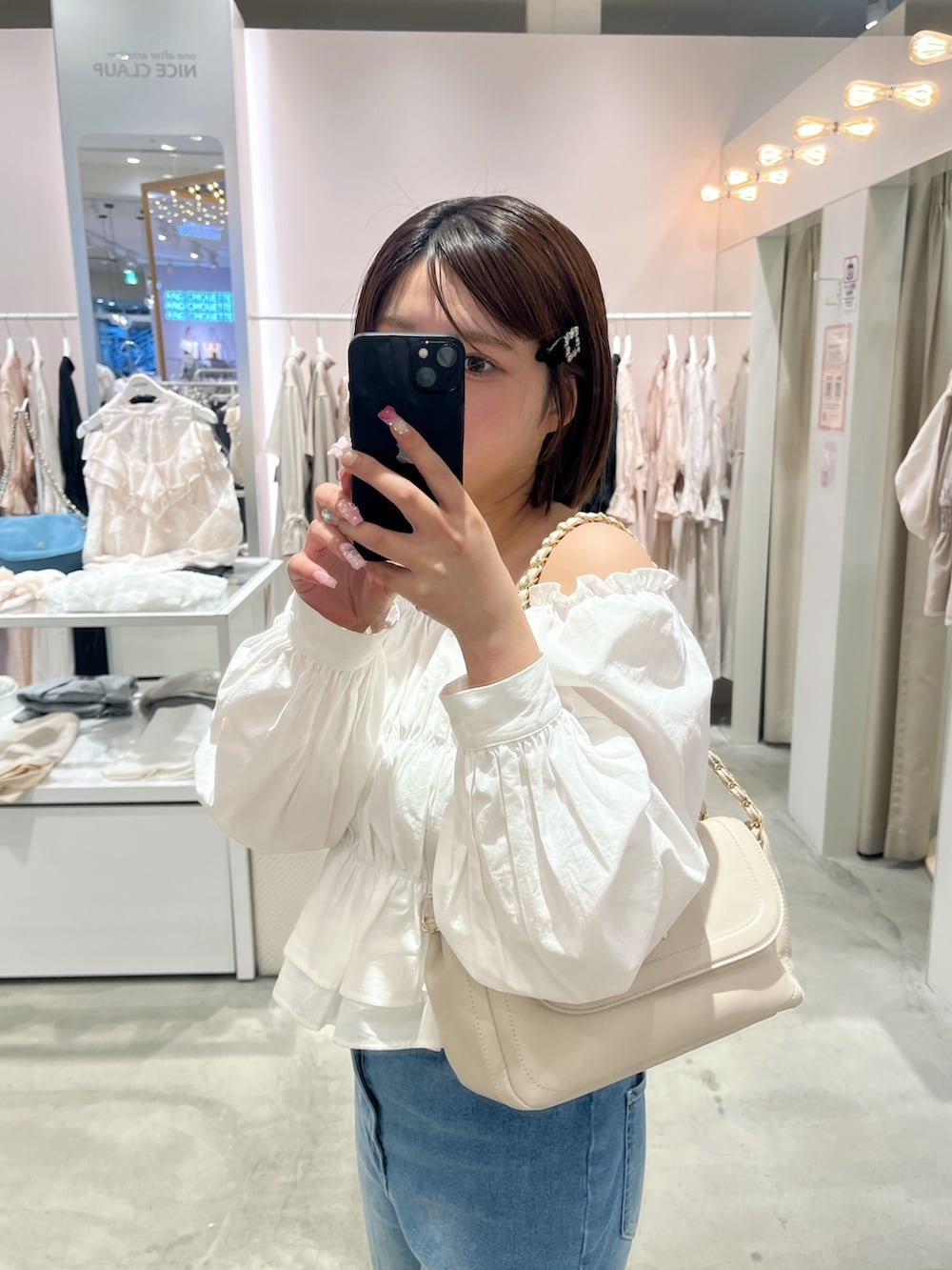 ホワイト系のシャツ/ブラウス、ブルー系のデニムパンツ、ベージュ系のショルダーバッグを着用したレディースの春コーディネートの2枚目の写真