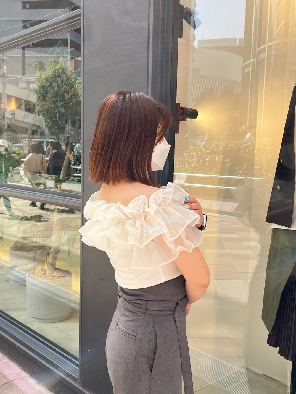 グレー系のスラックス、ホワイト系のシャツ/ブラウスを着用したレディースの春コーディネートの2枚目の写真