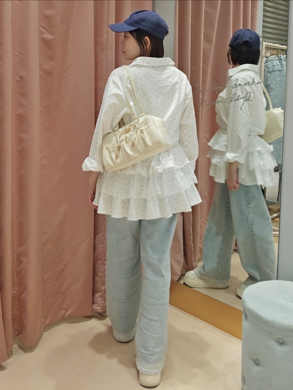 ホワイト系のボストンバッグ、ホワイト系のスニーカー、ブルー系のデニムパンツを着用したレディースの春コーディネートの4枚目の写真