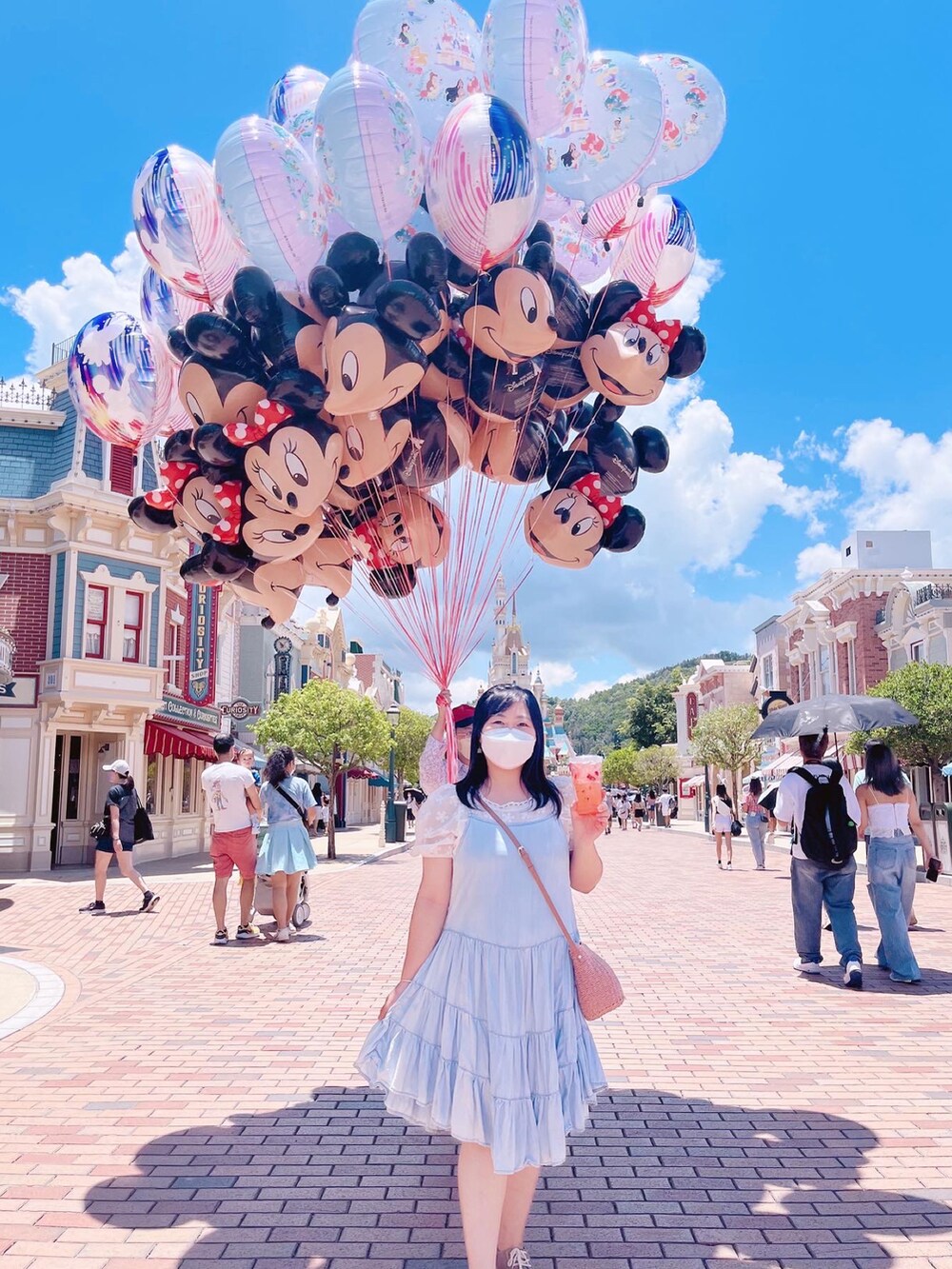 ブルー系のジャンパースカート、グリーン系のスリッポン、ホワイト系のシャツ/ブラウスを着用したレディースの夏コーディネートの2枚目の写真