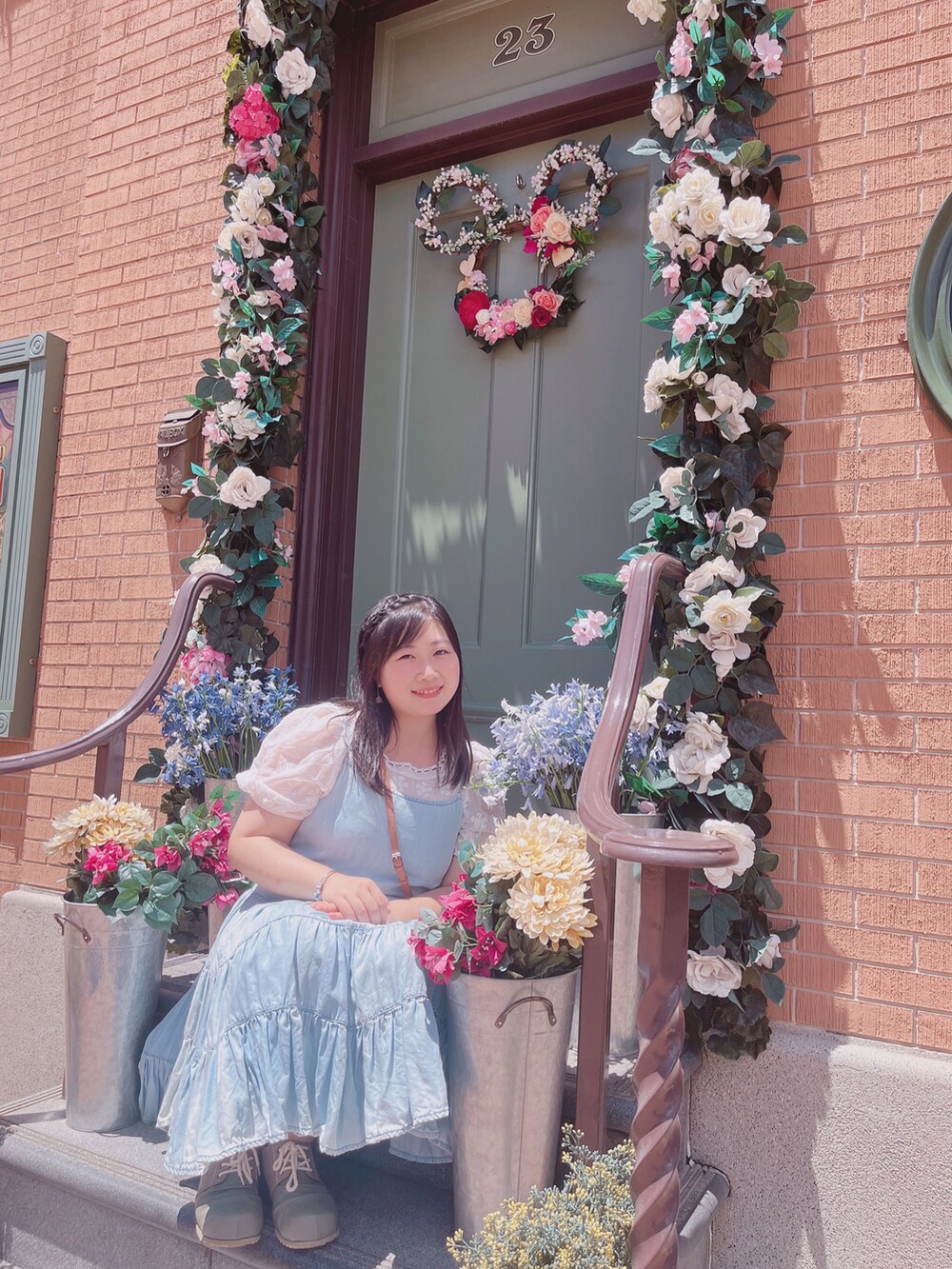 ブルー系のジャンパースカート、グリーン系のスリッポン、ホワイト系のシャツ/ブラウスを着用したレディースの夏コーディネートの4枚目の写真