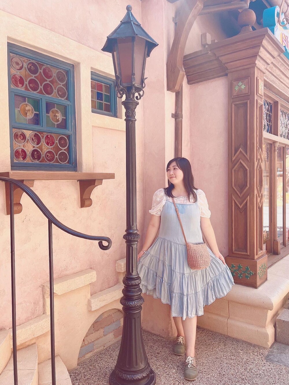 ブルー系のジャンパースカート、グリーン系のスリッポン、ホワイト系のシャツ/ブラウスを着用したレディースの夏コーディネートの3枚目の写真