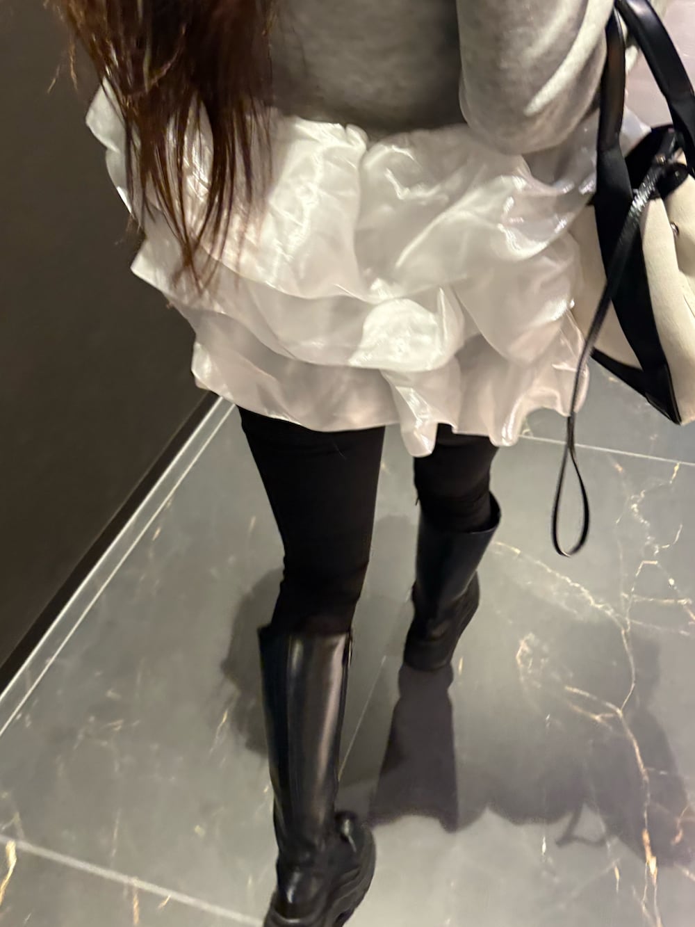 グレー系のトップスを着用したレディースの春コーディネートの2枚目の写真