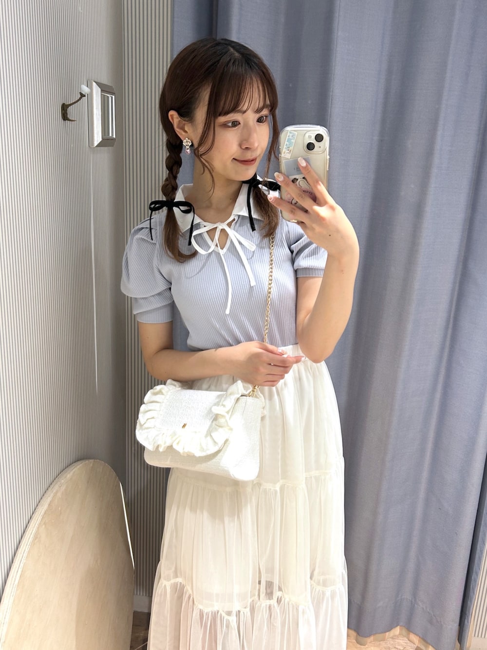 ブルー系のTシャツ/カットソー、ホワイト系のスカート、ホワイト系のショルダーバッグを着用したレディースの春コーディネートの2枚目の写真