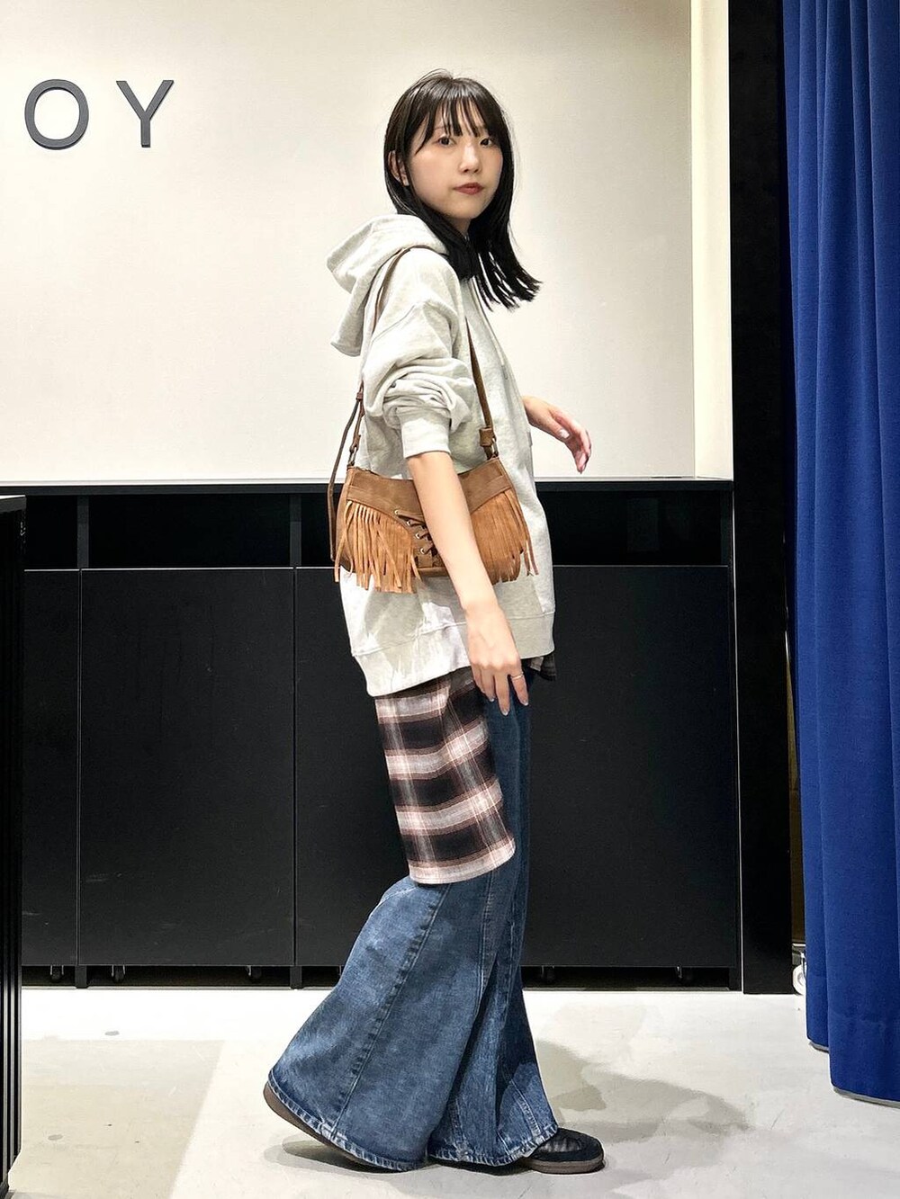 ベージュ系のショルダーバッグ、ブルー系のデニムパンツ、ブラウン系のシャツ/ブラウスを着用したレディースの夏コーディネートの4枚目の写真