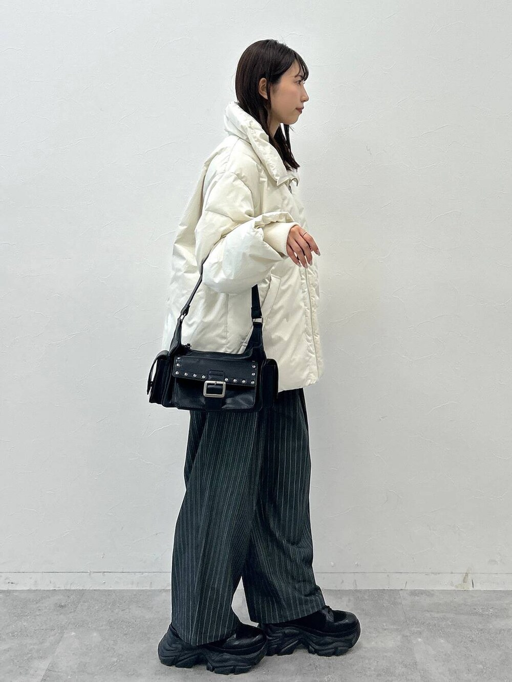 ブラック系のショルダーバッグ、ホワイト系のブルゾン、ホワイト系のTシャツ/カットソーを着用したレディースの秋コーディネートの6枚目の写真