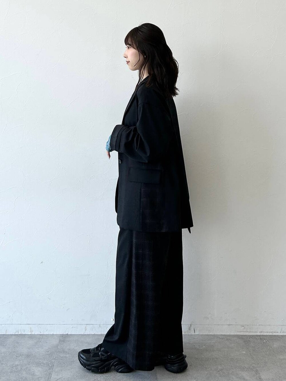 ブラック系のスニーカー、ブラック系のテーラードジャケット、ブラック系のスラックスを着用したレディースの夏コーディネートの9枚目の写真