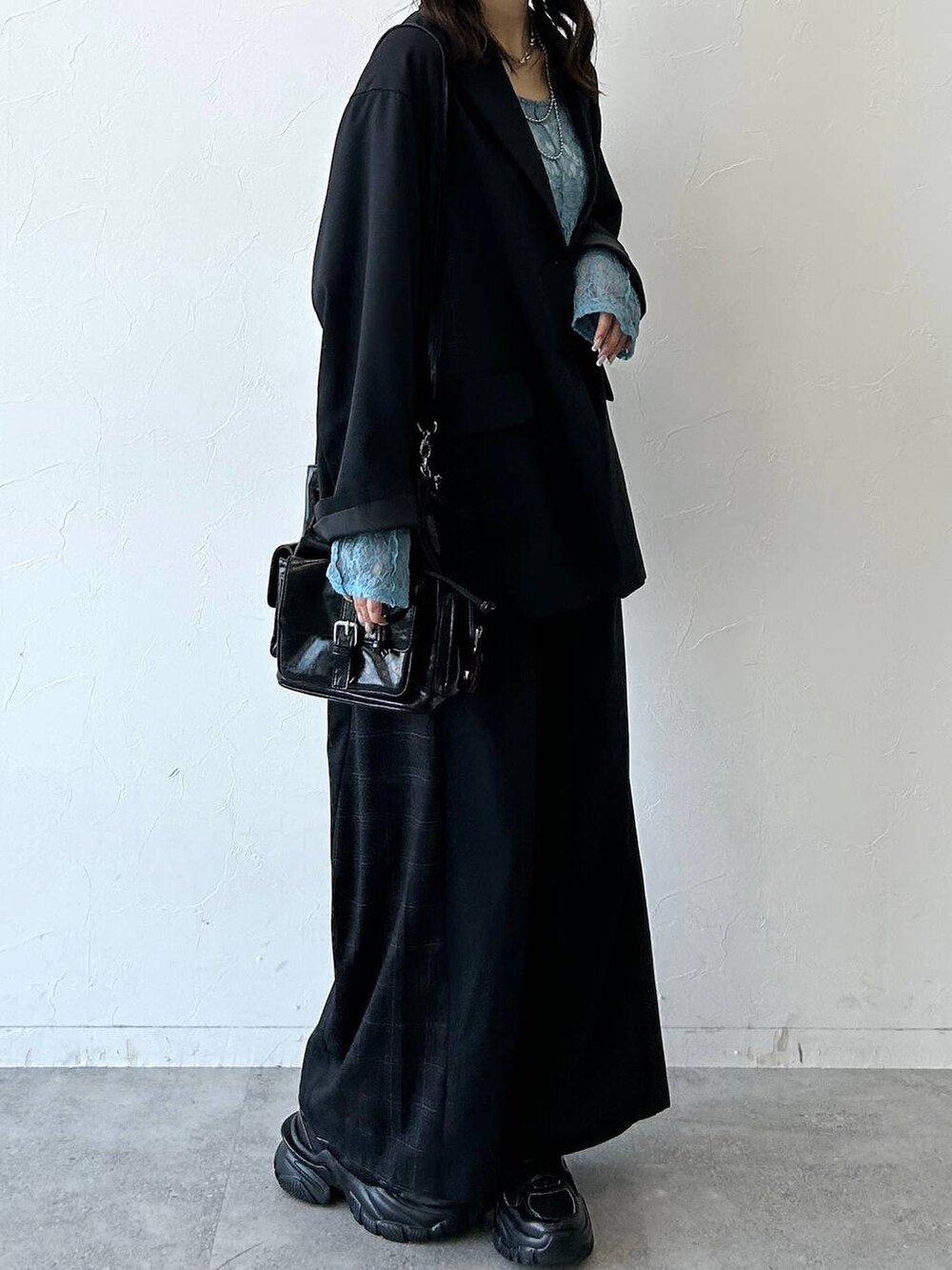 ブラック系のスニーカー、ブラック系のテーラードジャケット、ブラック系のスラックスを着用したレディースの夏コーディネートの8枚目の写真