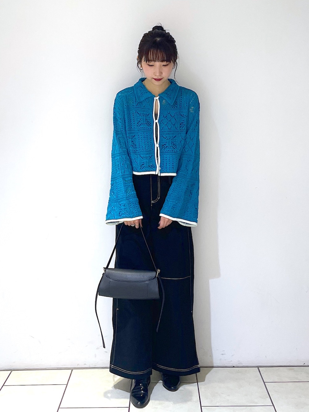 グリーン系のカーディガン/ボレロ、グレー系のタンクトップ、ブラック系のトートバッグを着用したレディースの春コーディネートの2枚目の写真