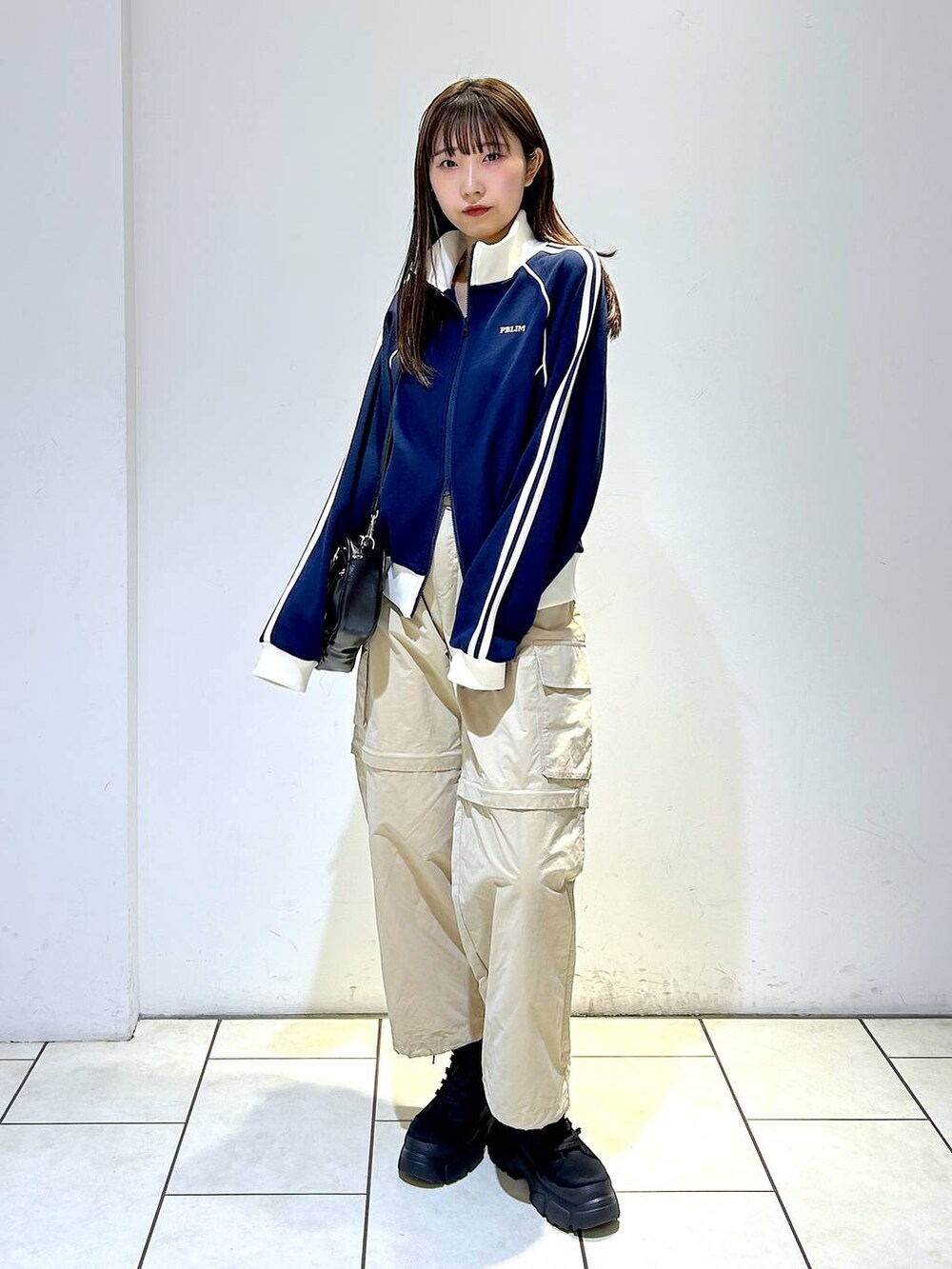 ブルー系のセットアップ、ブラック系のボストンバッグ、ブラック系のブーツを着用したレディースの冬コーディネートの4枚目の写真