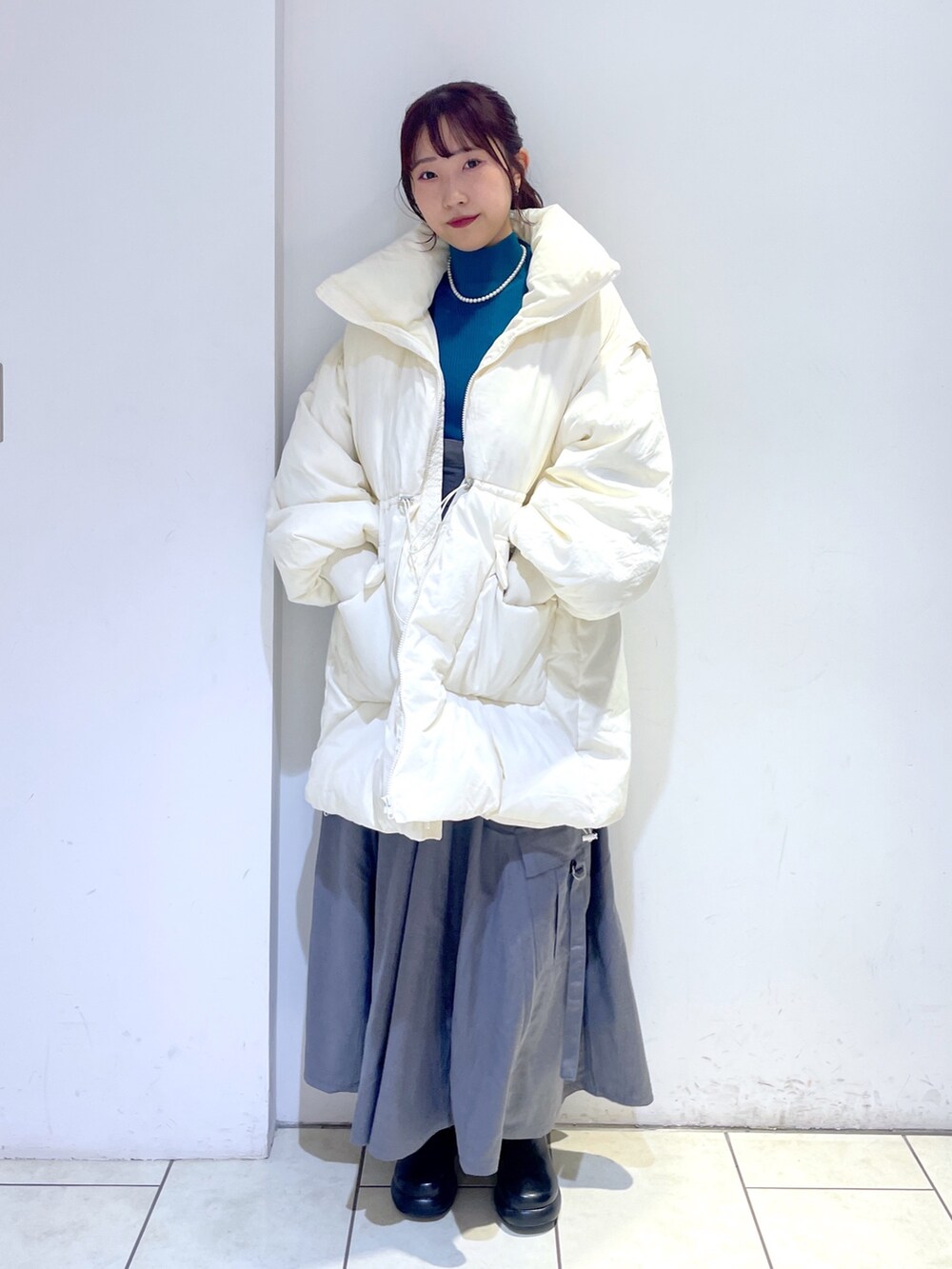 ブラック系のブーツ、グレー系のジャンパースカート、ホワイト系のジャケット/アウターを着用したレディースの秋コーディネートの2枚目の写真