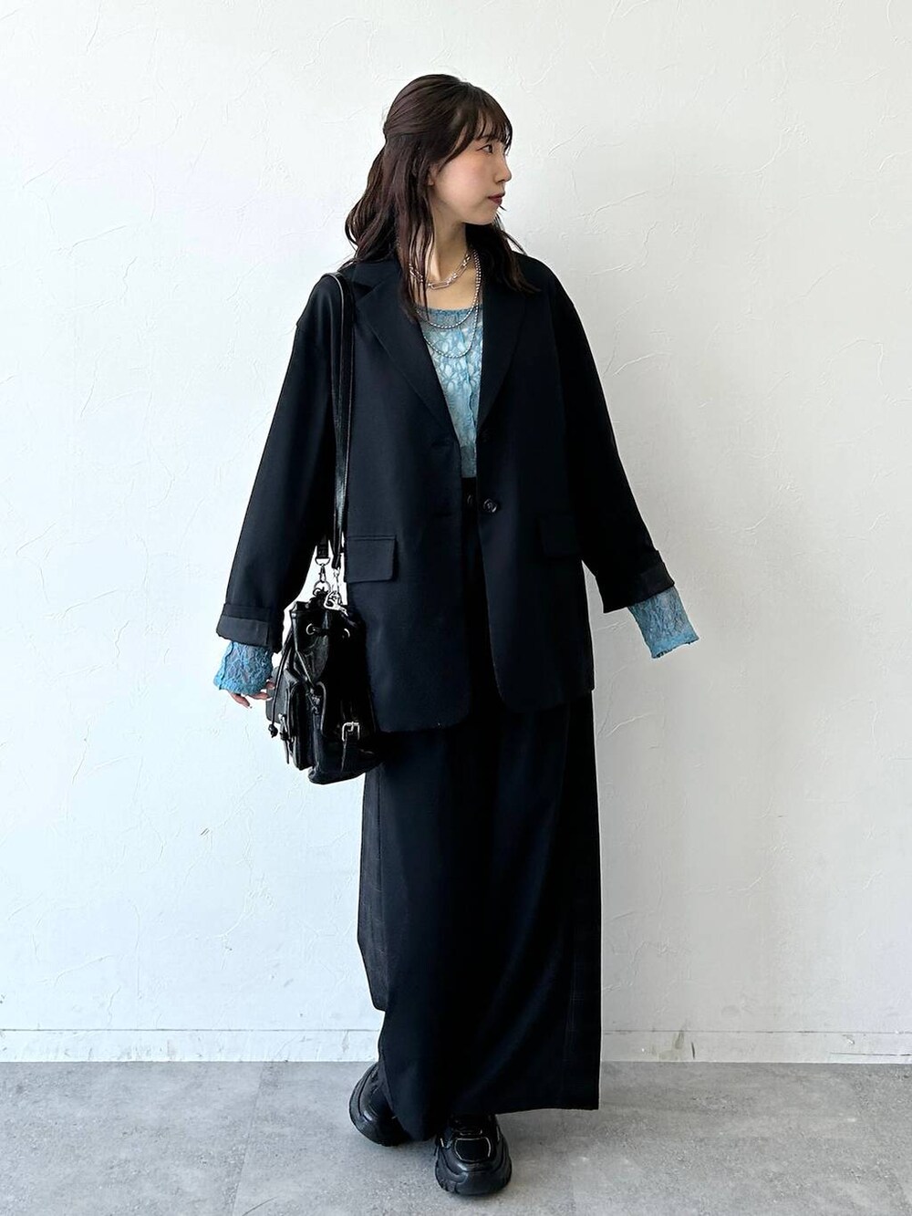 ブラック系のスニーカー、ブラック系のテーラードジャケット、ブラック系のスラックスを着用したレディースの夏コーディネートの3枚目の写真