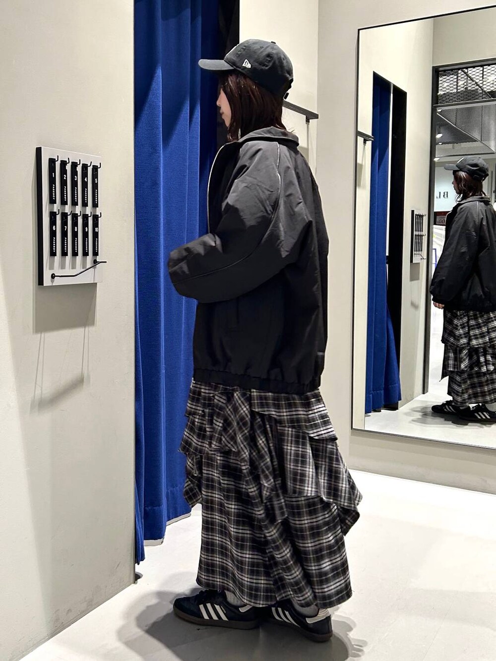 ブラック系のスカート、ブラック系のニット/セーター、ブラック系のナイロンジャケットを着用したレディースの冬コーディネートの5枚目の写真