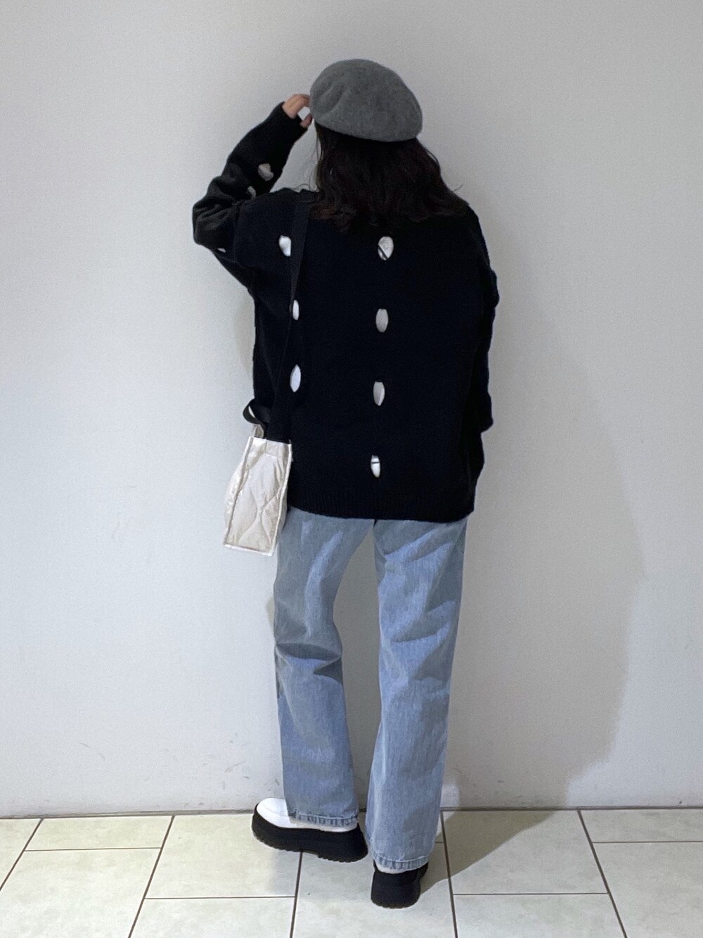 ブラック系のニット/セーター、ホワイト系のTシャツ/カットソー、ブルー系のデニムパンツを着用したレディースの冬コーディネートの3枚目の写真