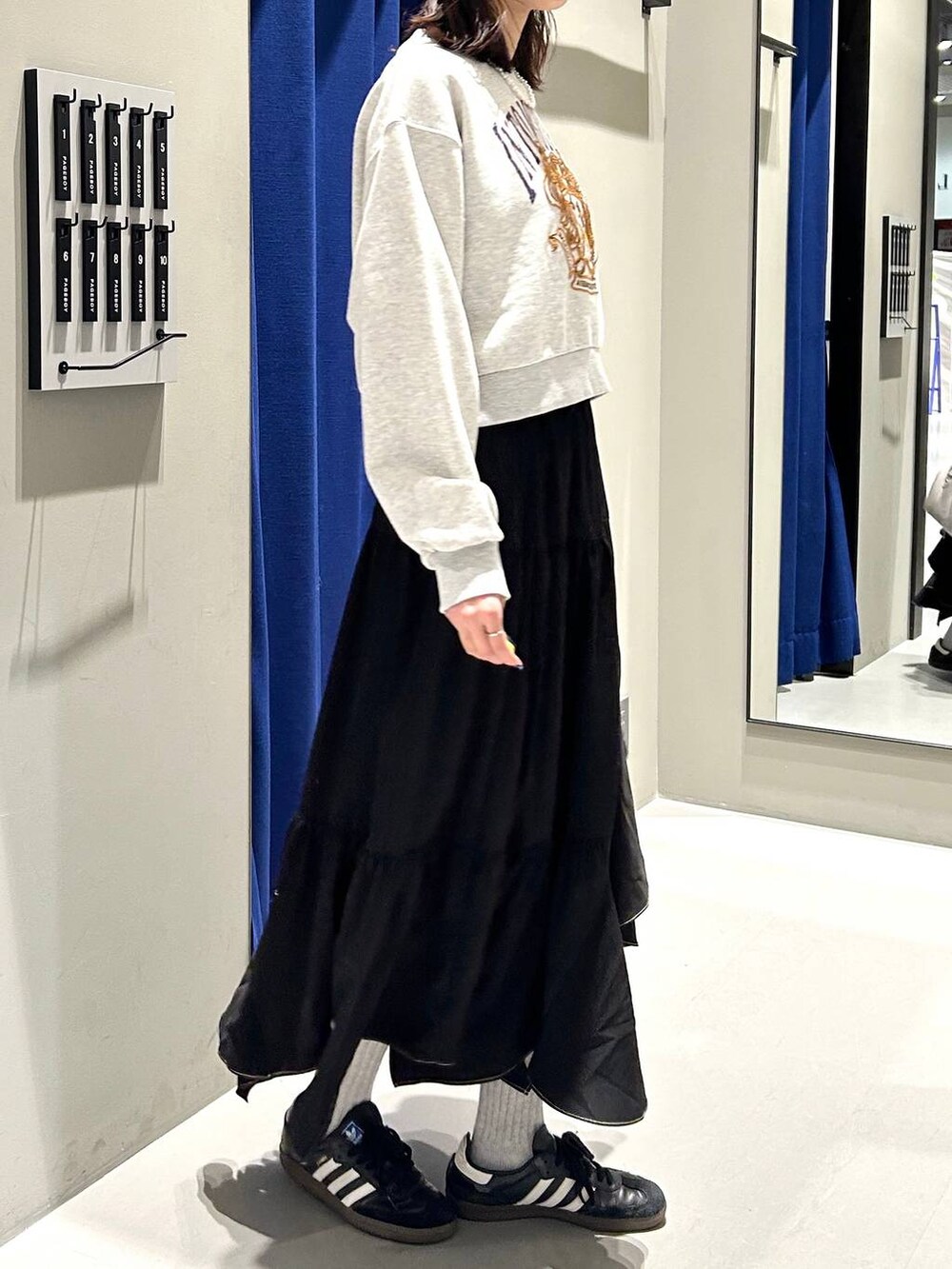 ブラック系のスカート、ホワイト系のボストンバッグ、グレー系のスウェットを着用したレディースの冬コーディネートの6枚目の写真