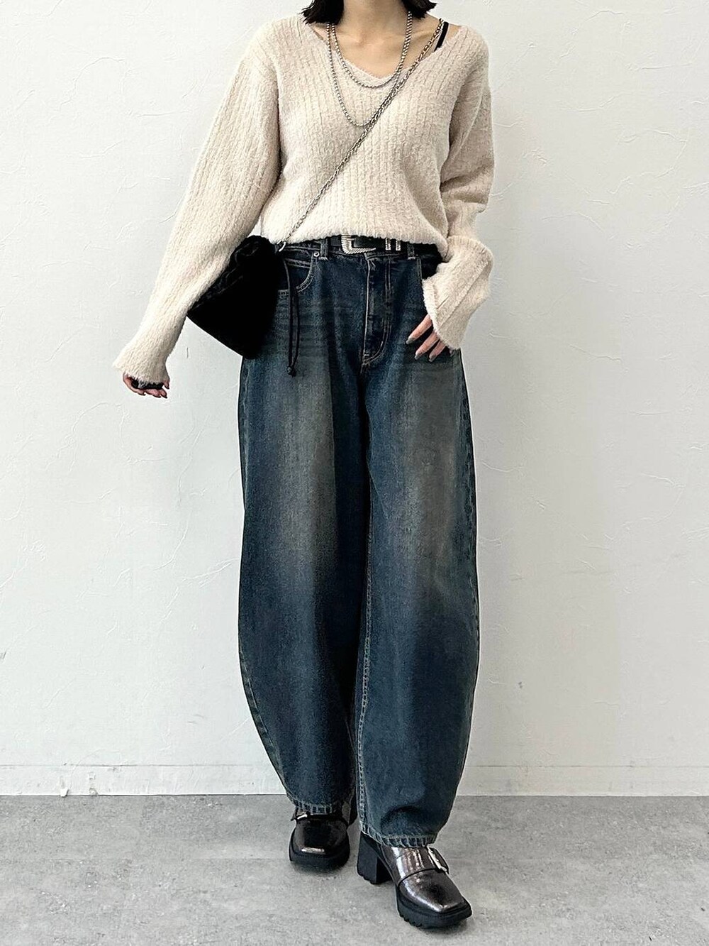 ベージュ系のニット/セーター、その他のブーツ、ブラック系のハンドバッグを着用したレディースの冬コーディネートの3枚目の写真