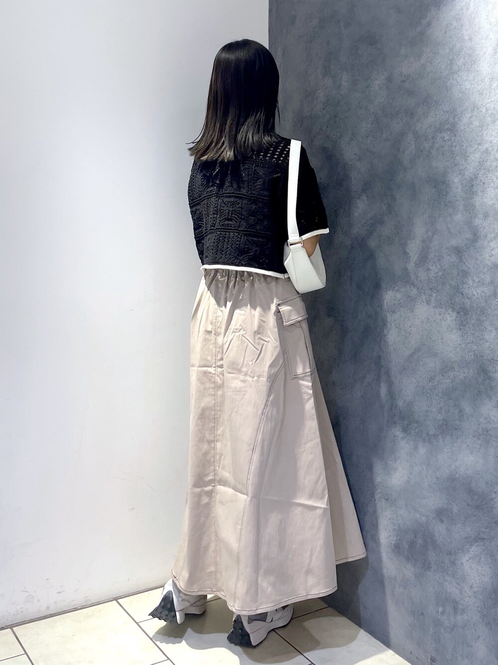 ブラック系のカーディガン/ボレロ、ホワイト系のバッグ、ブラウン系のスカートを着用したレディースの夏コーディネートの2枚目の写真