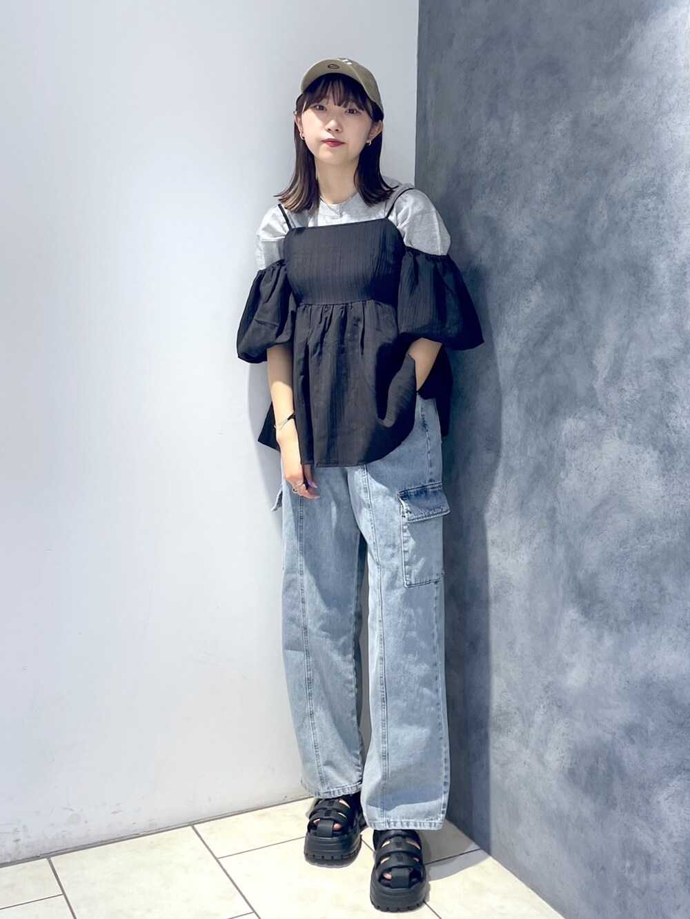 ブラック系のシャツ/ブラウス、グレー系のTシャツ/カットソー、ブルー系のデニムパンツを着用したレディースの春コーディネートの2枚目の写真