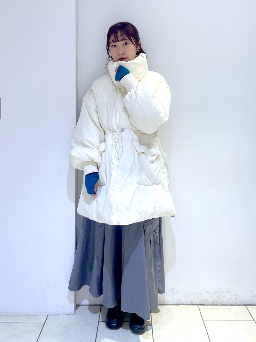 ブラック系のブーツ、グレー系のジャンパースカート、ホワイト系のジャケット/アウターを着用したレディースの秋コーディネートの4枚目の写真