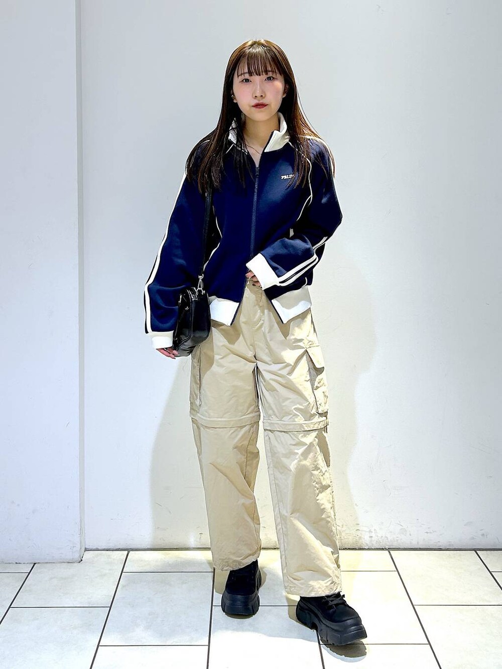 ブルー系のセットアップ、ブラック系のボストンバッグ、ブラック系のブーツを着用したレディースの冬コーディネートの3枚目の写真