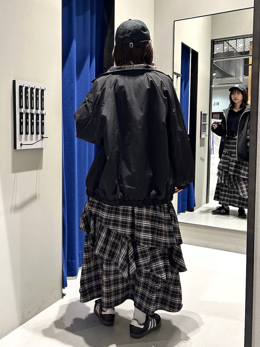 ブラック系のスカート、ブラック系のニット/セーター、ブラック系のナイロンジャケットを着用したレディースの冬コーディネートの7枚目の写真