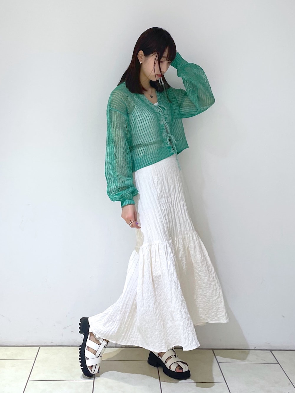 ホワイト系のキャミソール、ホワイト系のスカート、ホワイト系のサンダルを着用したレディースの春コーディネートの3枚目の写真