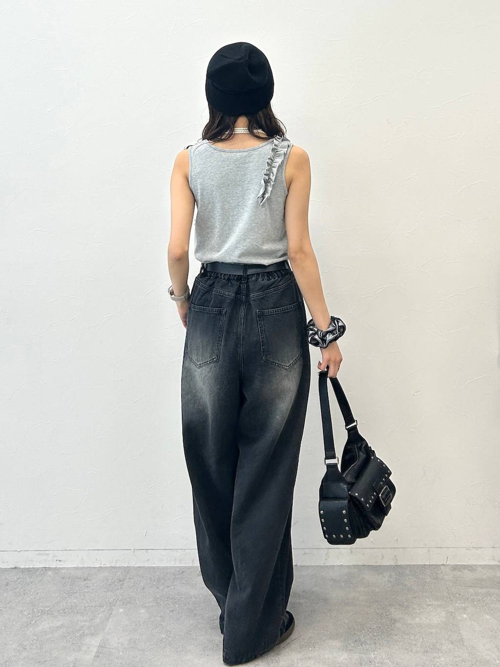 ブラック系のショルダーバッグ、グレー系のタンクトップ、ブラック系のデニムパンツを着用したレディースの夏コーディネートの7枚目の写真