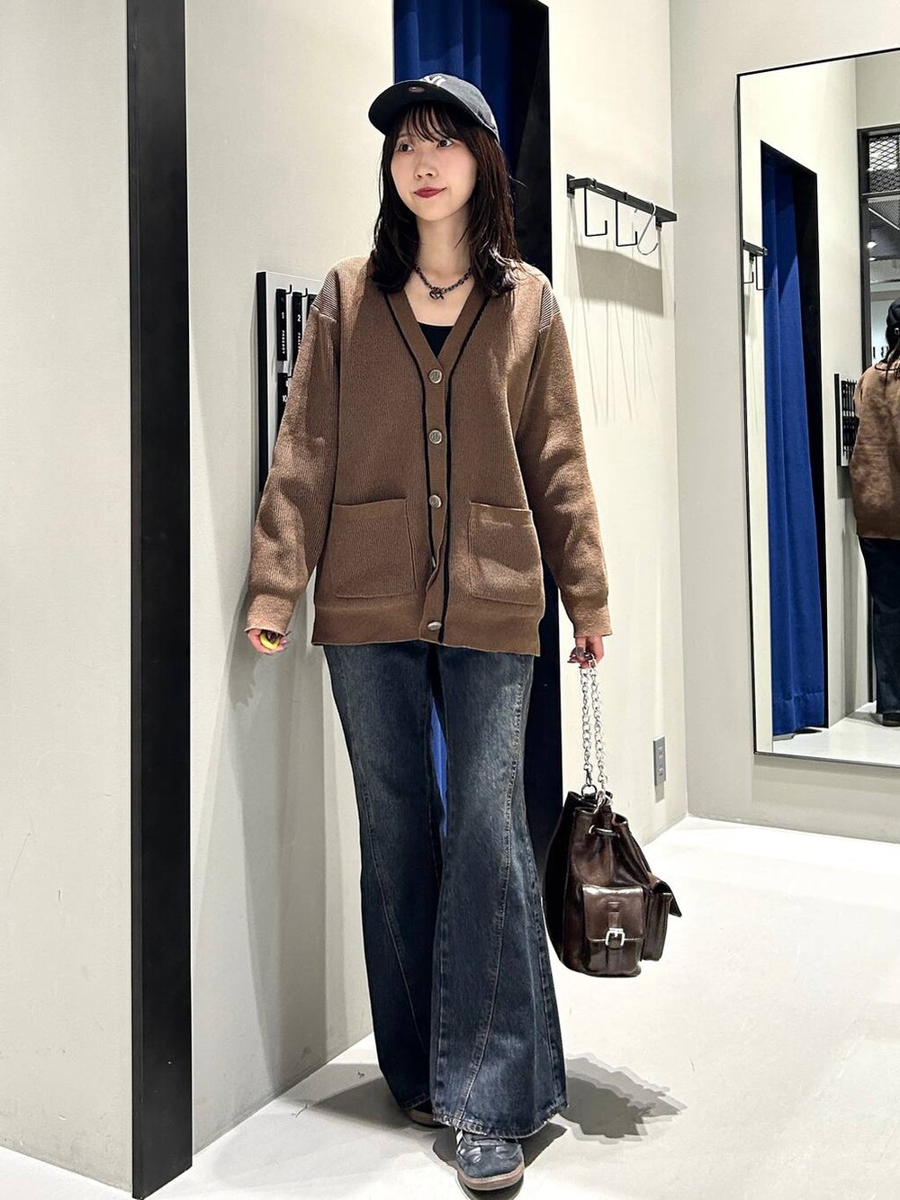 ブラック系のキャミソール、ブルー系のデニムパンツ、ブラウン系のショルダーバッグを着用したレディースの秋コーディネートの4枚目の写真