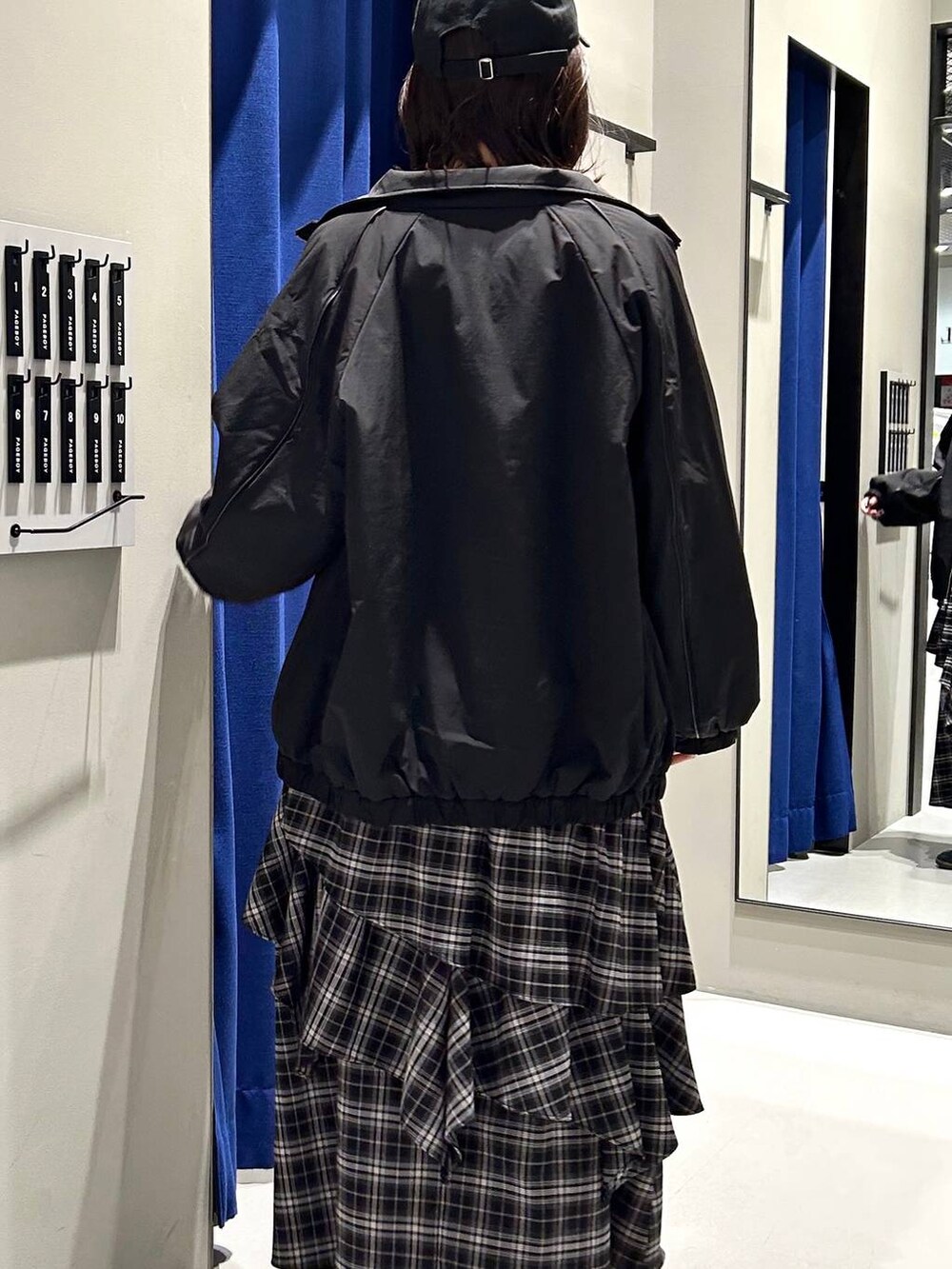 ブラック系のスカート、ブラック系のニット/セーター、ブラック系のナイロンジャケットを着用したレディースの冬コーディネートの4枚目の写真