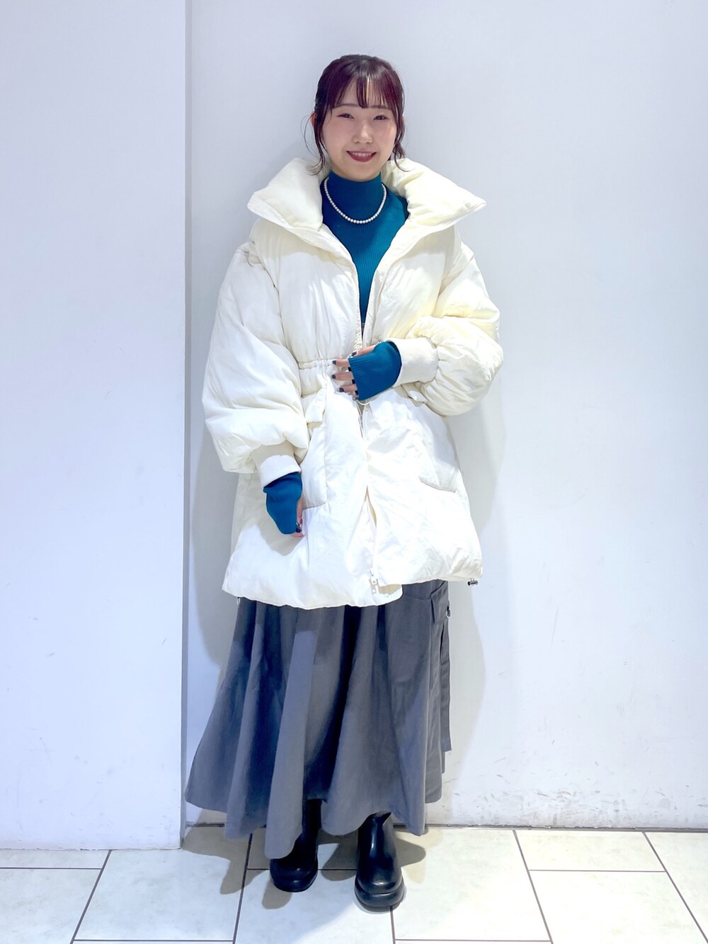 ブラック系のブーツ、グレー系のジャンパースカート、ホワイト系のジャケット/アウターを着用したレディースの秋コーディネートの3枚目の写真