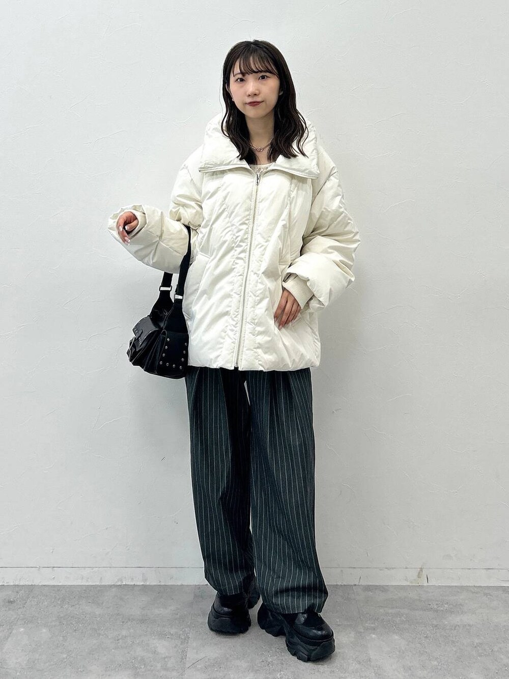 ブラック系のショルダーバッグ、ホワイト系のブルゾン、ホワイト系のTシャツ/カットソーを着用したレディースの秋コーディネートの2枚目の写真