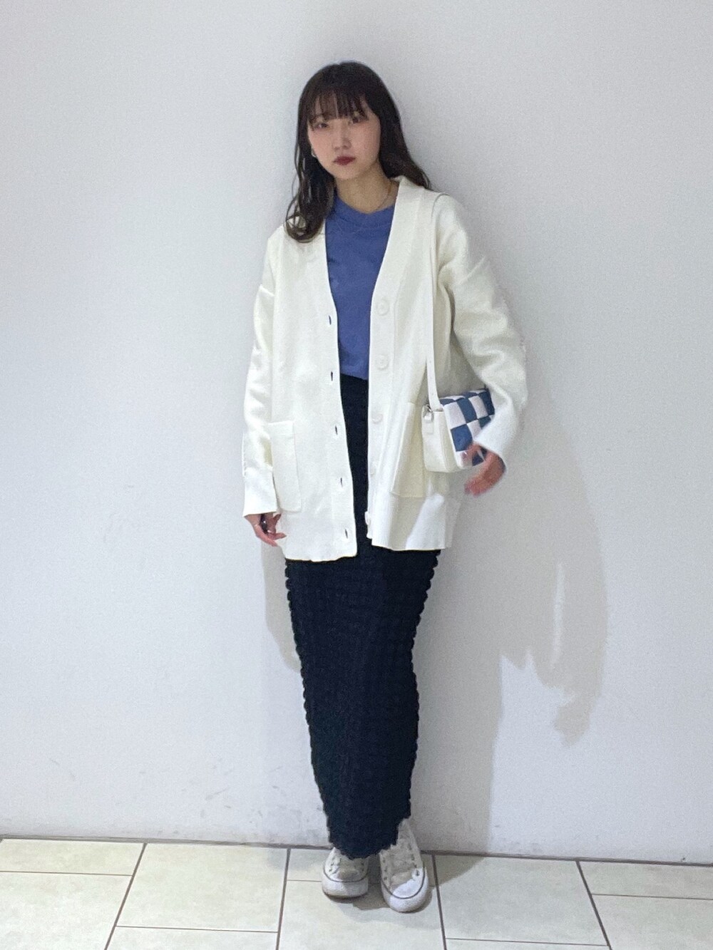 ホワイト系のカーディガン/ボレロ、ブルー系のTシャツ/カットソー、ブラック系のスカートを着用したレディースの冬コーディネートの2枚目の写真