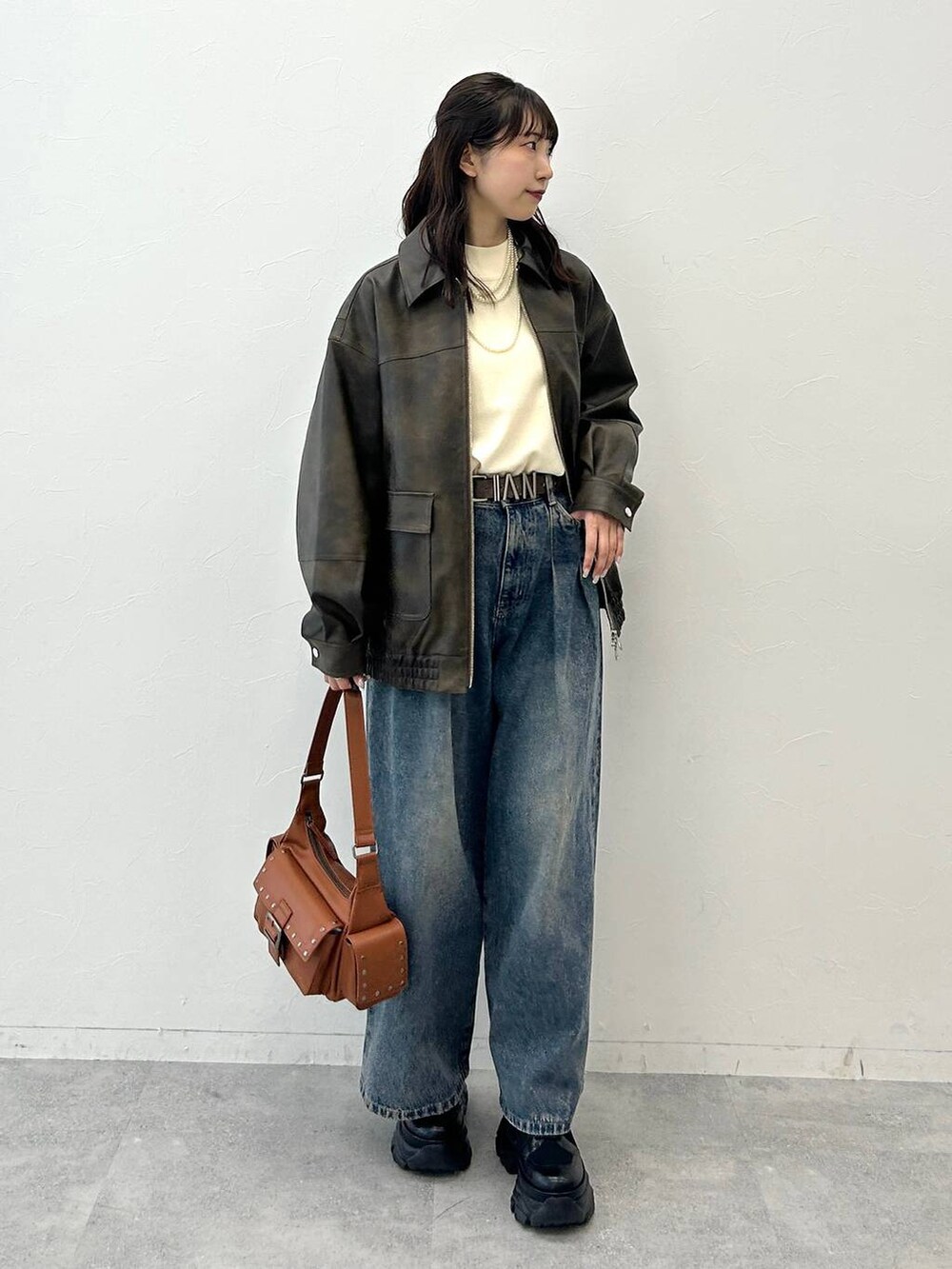 ブラック系のブーツ、ブルー系のデニムパンツ、ホワイト系のニット/セーターを着用したレディースの夏コーディネートの2枚目の写真