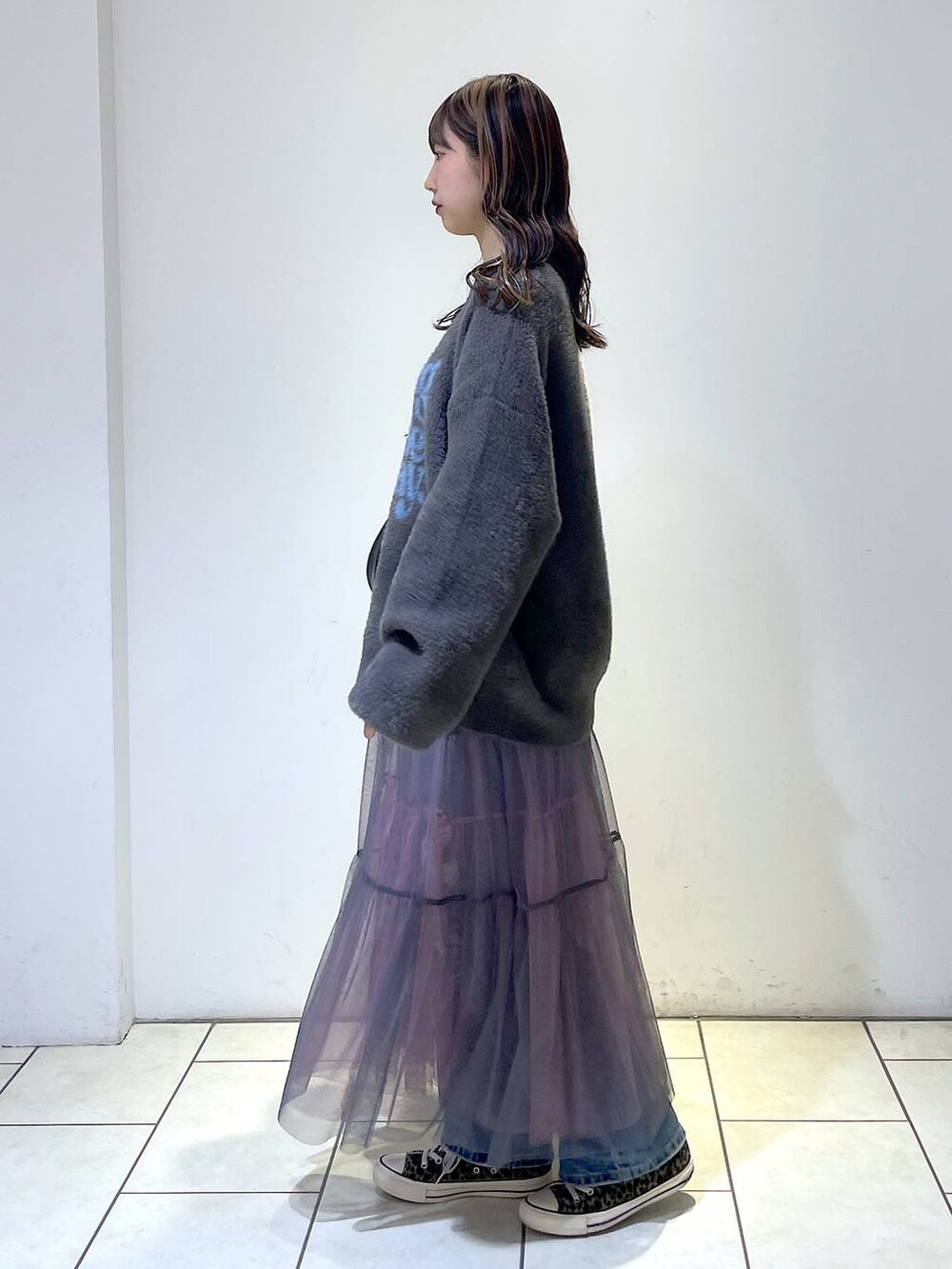 ブルー系のデニムパンツ、ブラック系のショルダーバッグ、グレー系のニット/セーターを着用したレディースの冬コーディネートの4枚目の写真