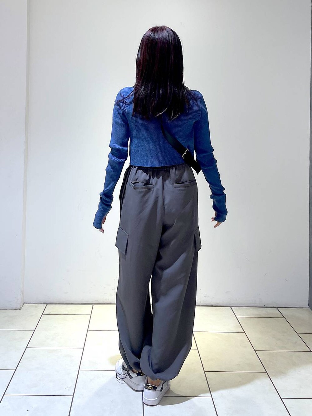 グレー系のその他パンツ、ブラック系のショルダーバッグ、ブルー系のニット/セーターを着用したレディースの冬コーディネートの6枚目の写真