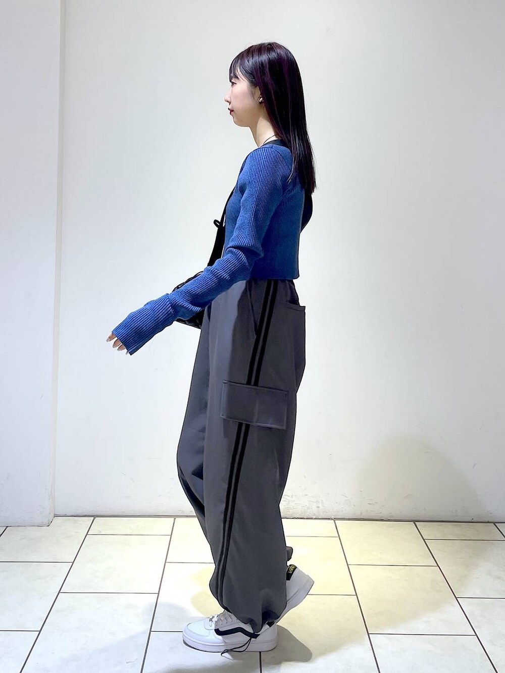 グレー系のその他パンツ、ブラック系のショルダーバッグ、ブルー系のニット/セーターを着用したレディースの冬コーディネートの5枚目の写真