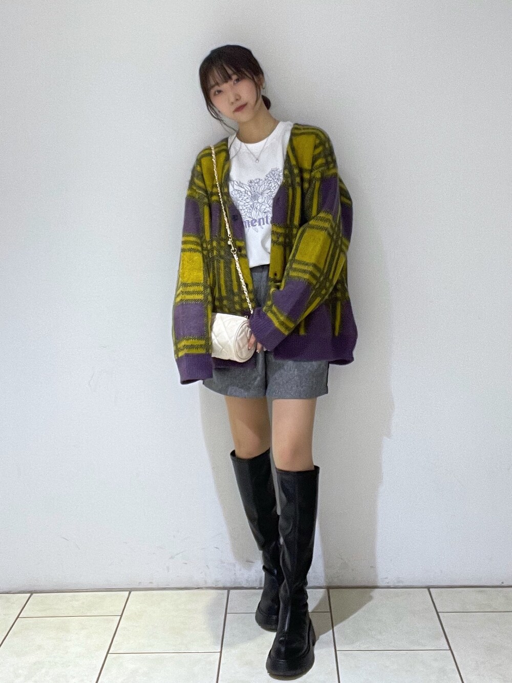 イエロー系のカーディガン/ボレロ、ホワイト系のTシャツ/カットソー、ブラック系のその他パンツを着用したレディースの冬コーディネートの2枚目の写真