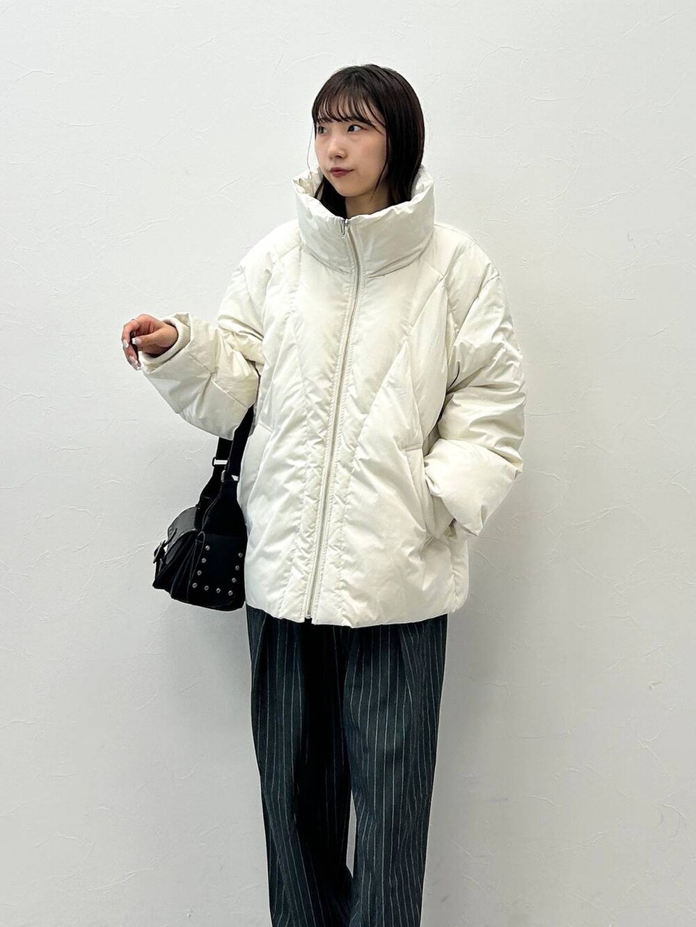 ブラック系のショルダーバッグ、ホワイト系のブルゾン、ホワイト系のTシャツ/カットソーを着用したレディースの秋コーディネートの7枚目の写真