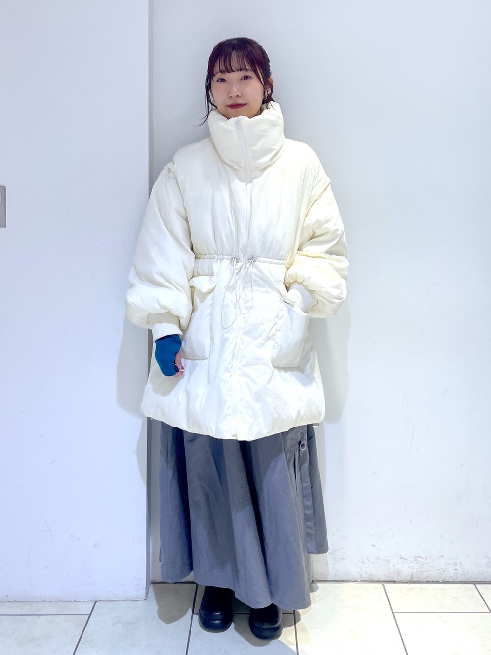 ブラック系のブーツ、グレー系のジャンパースカート、ホワイト系のジャケット/アウターを着用したレディースの秋コーディネートの5枚目の写真