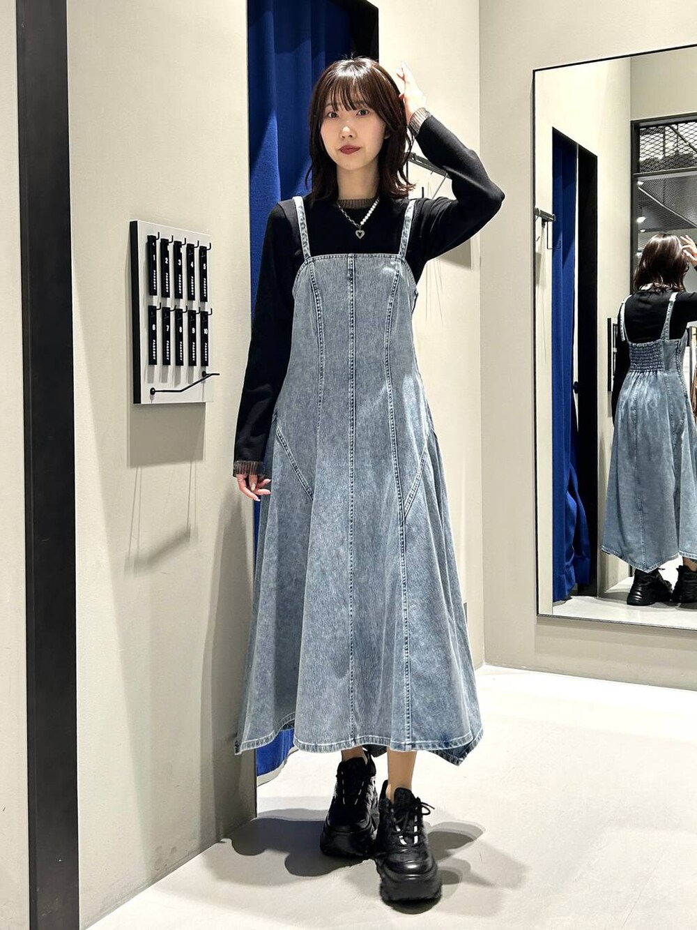 ブラック系のスニーカー、ブラック系のボストンバッグ、ブラック系のニット/セーターを着用したレディースの冬コーディネートの3枚目の写真
